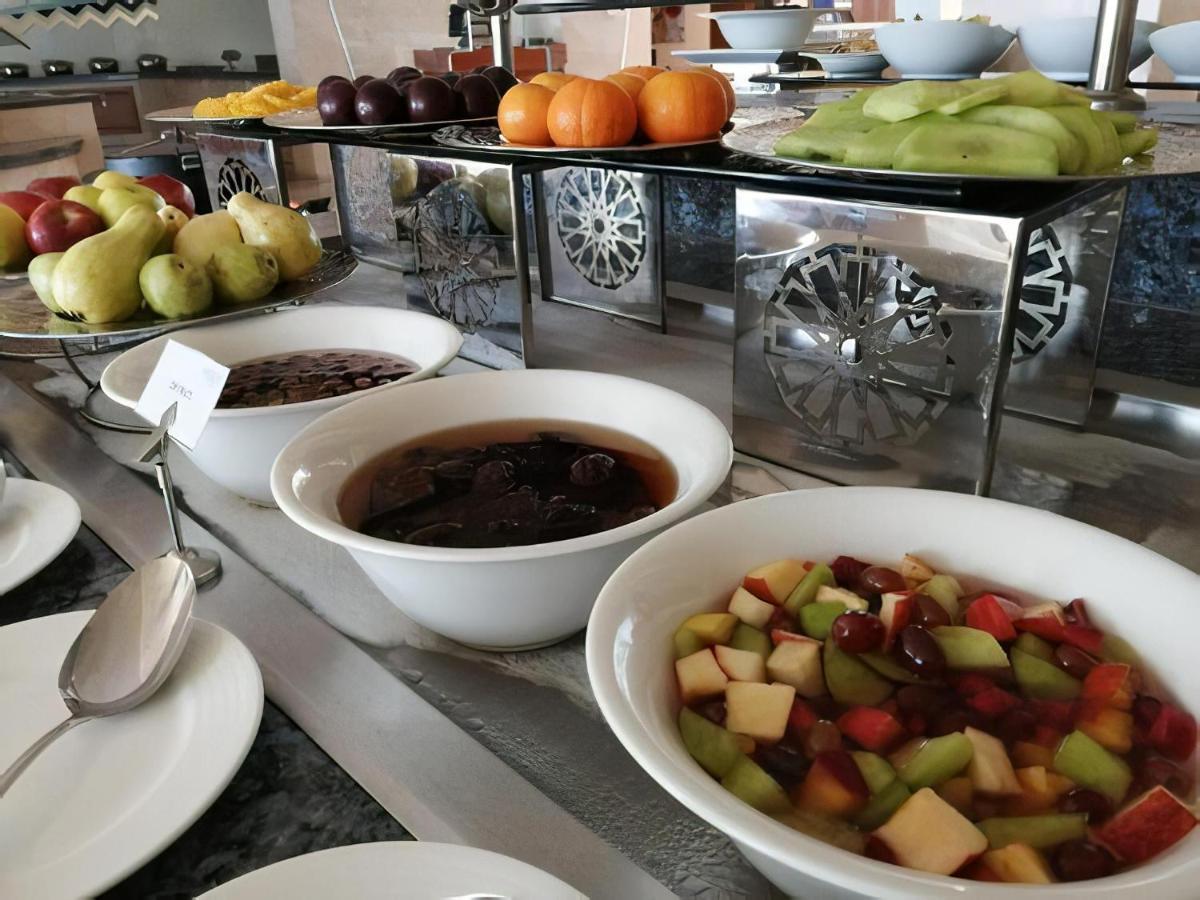 Tolip Resort El Galala Majestic Ain Sukhna Eksteriør bilde The photo shows a buffet-style arrangement of various fruits and fruit dishes. In the foreground, there are several bowls containing different types of fruit. One bowl has a fruit salad made with diced apples, green apples, and possibly other fruits.